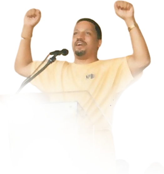 Pastor Watson preaching with both arms raised